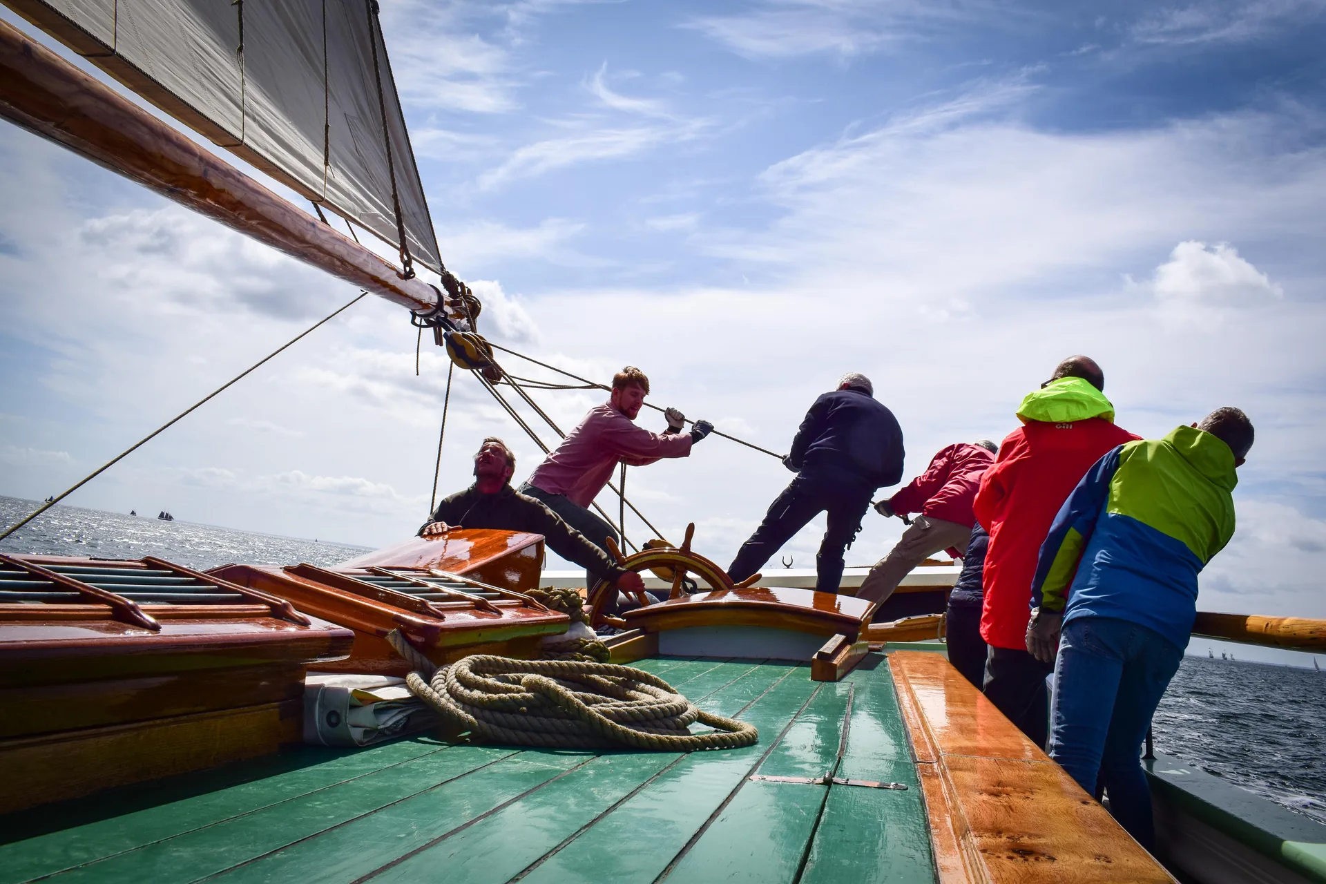 Guests haul together on a line aboard Aron